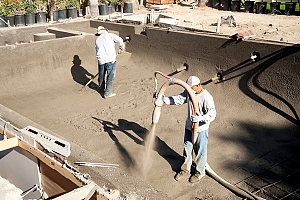 Men installing concrete pool