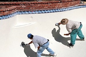 Worker renovating concrete pool