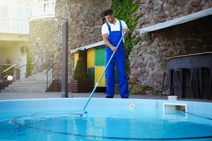 professional man cleaning pool